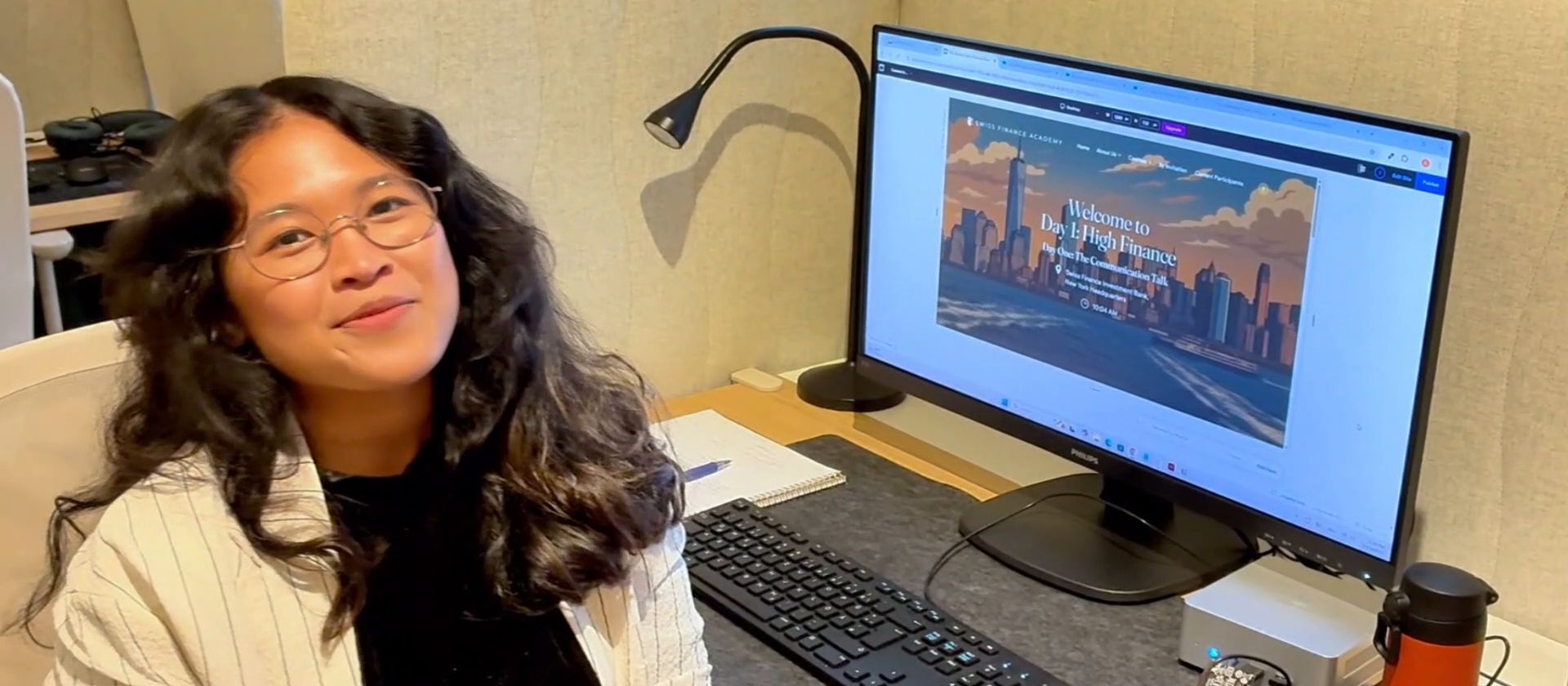 An intern smiling at her desk in the studio