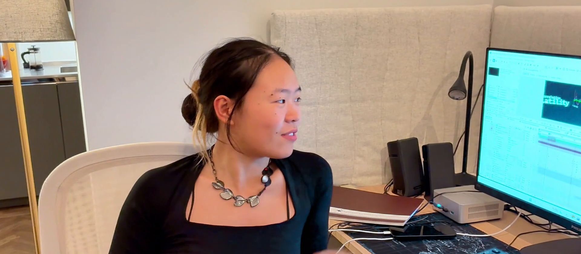 An intern at her desk in the studio, talking about her work