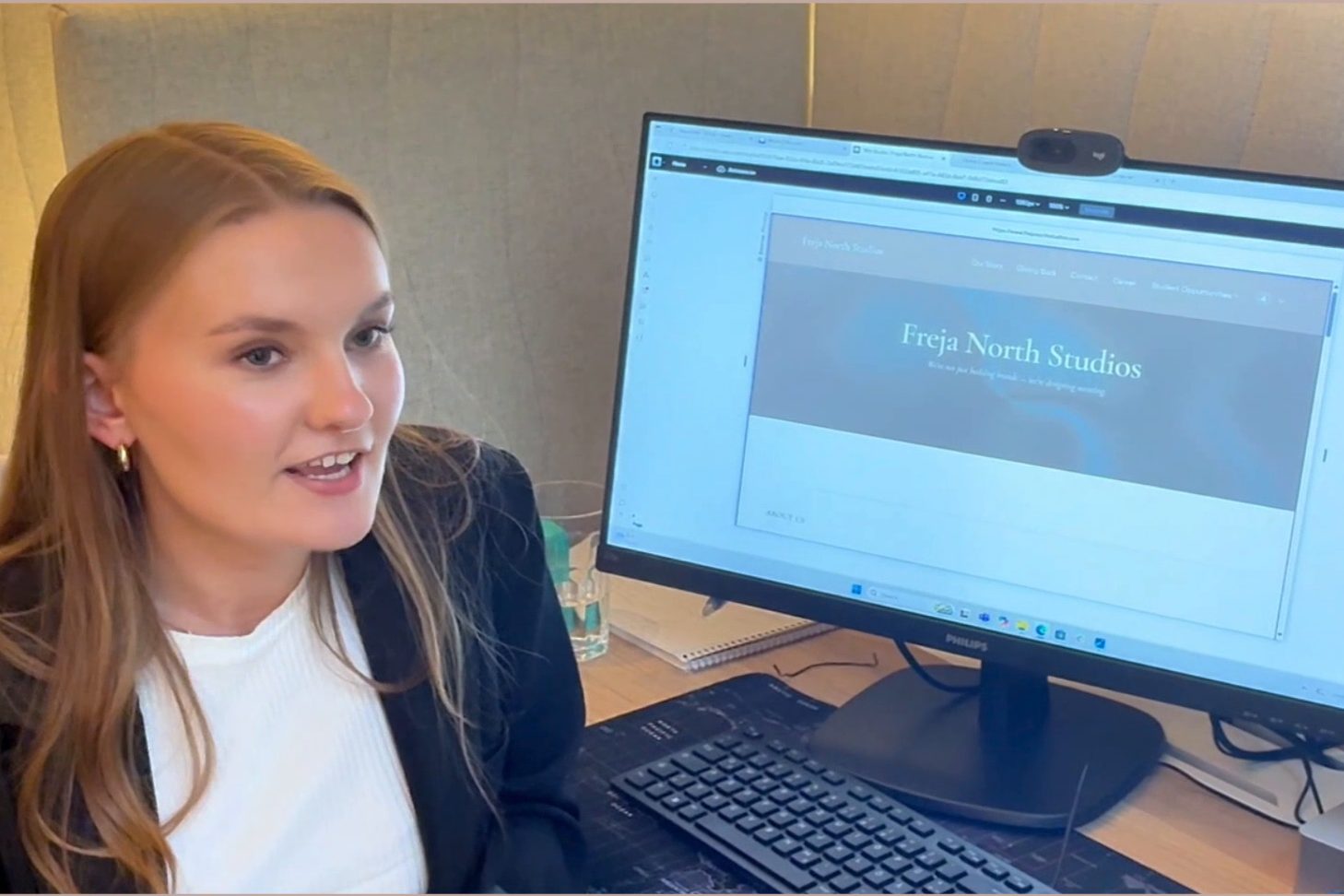 A designer at her desk in the studio with a website open on screen